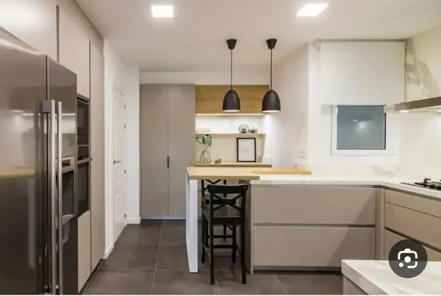 Cocina moderna en tonos grises con barra alta y mobiliario integrado