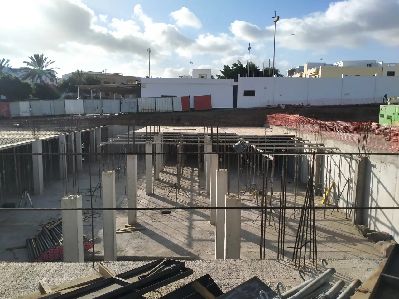 Pilares de hormigón recién desencofrados con sus esperas, y al fondo el forjado encofrado sobre puntales